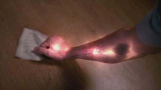 Sam's arm glows after reading the spell.